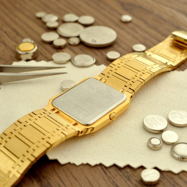 Geöffnete Armbanduhr mit Werkzeug und Knopfzellen beim Batteriewechsel